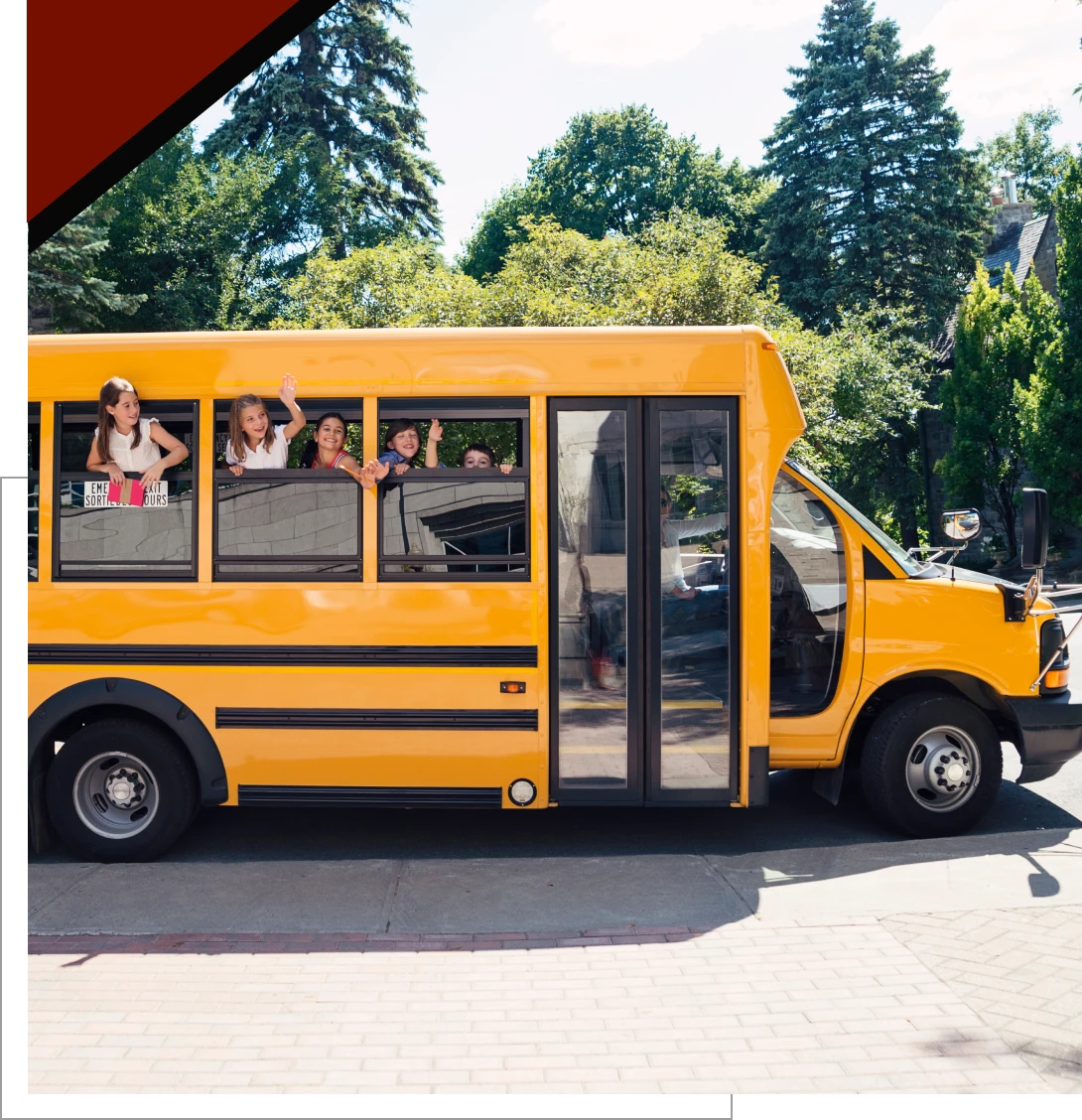 Children waving from a yellow school bus