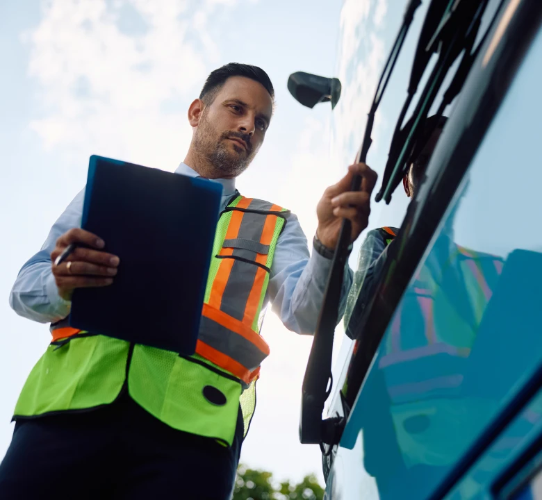 Man in safety vest checks bus